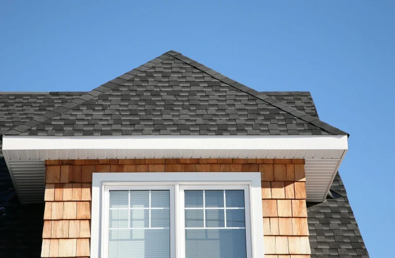 Dormer with cedar shake siding and a dark shingle roof