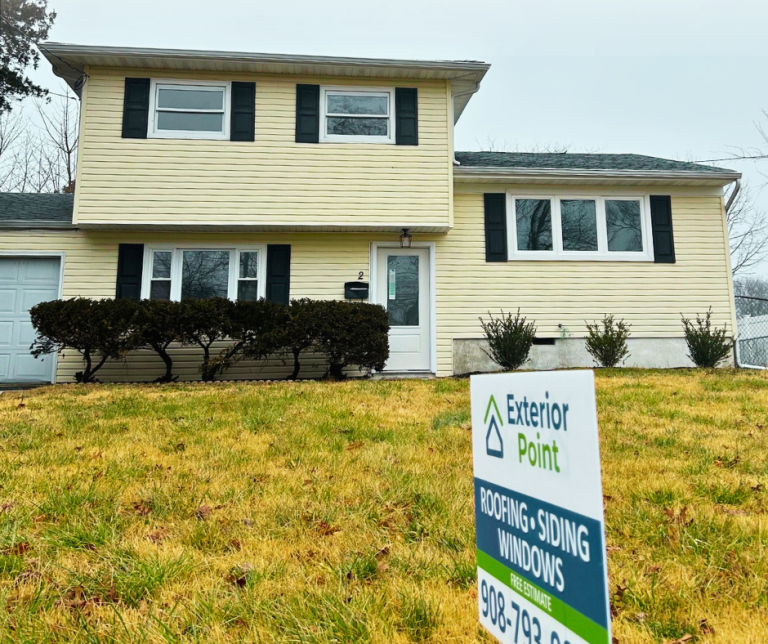 Exterior Point roofing, siding and windows yard sign in front of a yellow colonial in Middletown, NJ