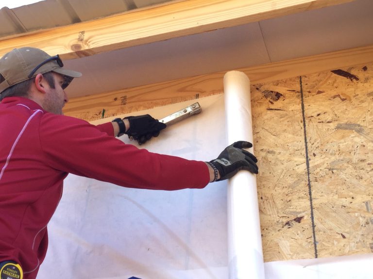 Installer applying new house wrap before new siding goes on