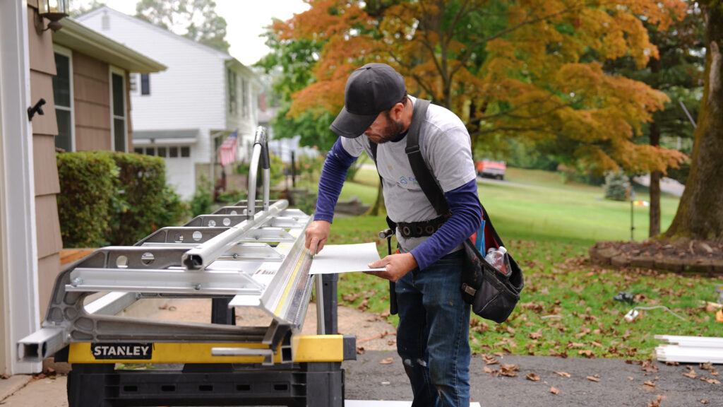 Window installer measuring and preparing a replacement window