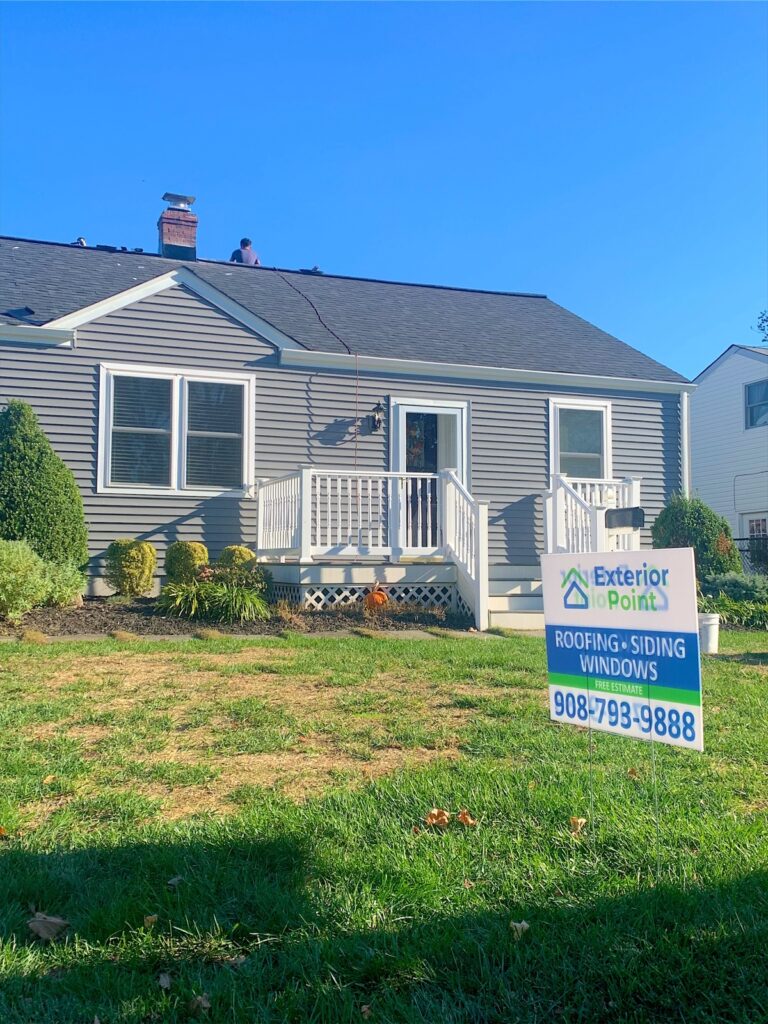Exterior Point yard sign in front of a gray ranch during a roof replacement near Eatontown, NJ