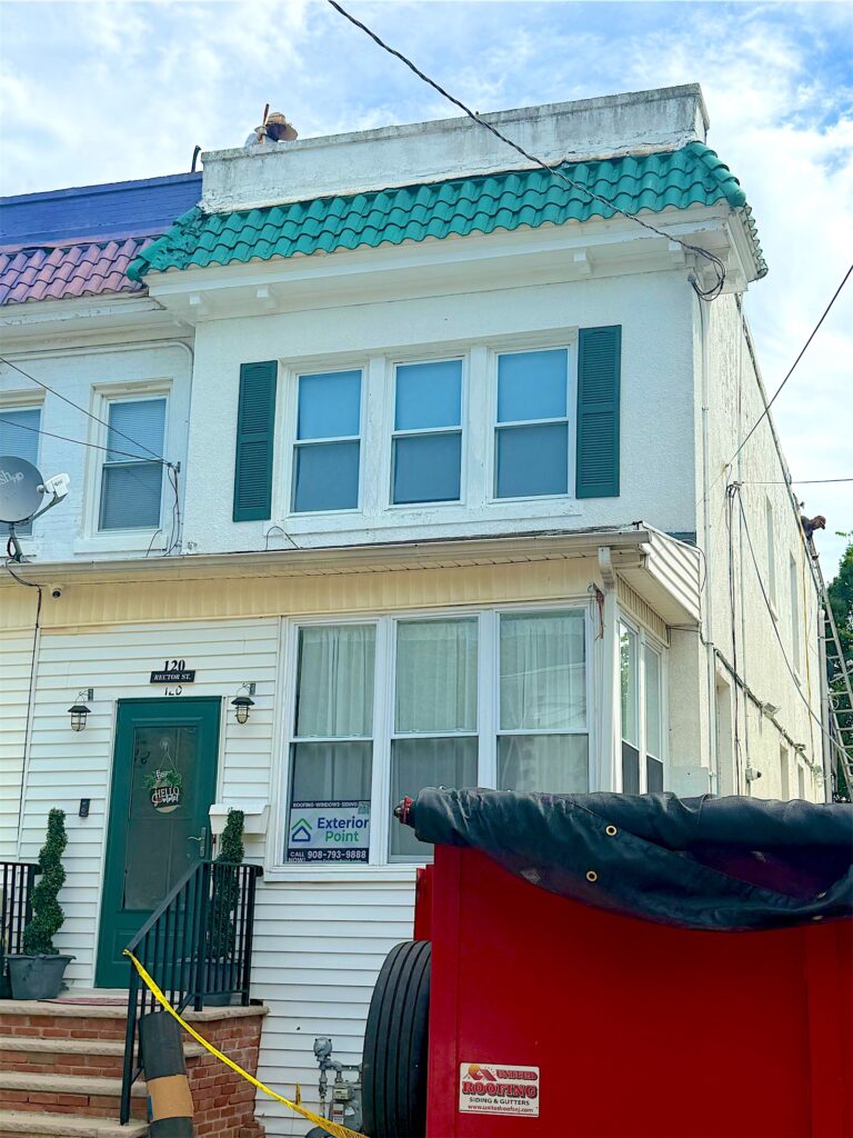 Dumpster outside a two-story home during an exterior project in Perth Amboy, NJ