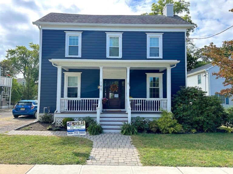 Two-story colonial with new navy blue siding and a white front porch in Red Bank, NJ