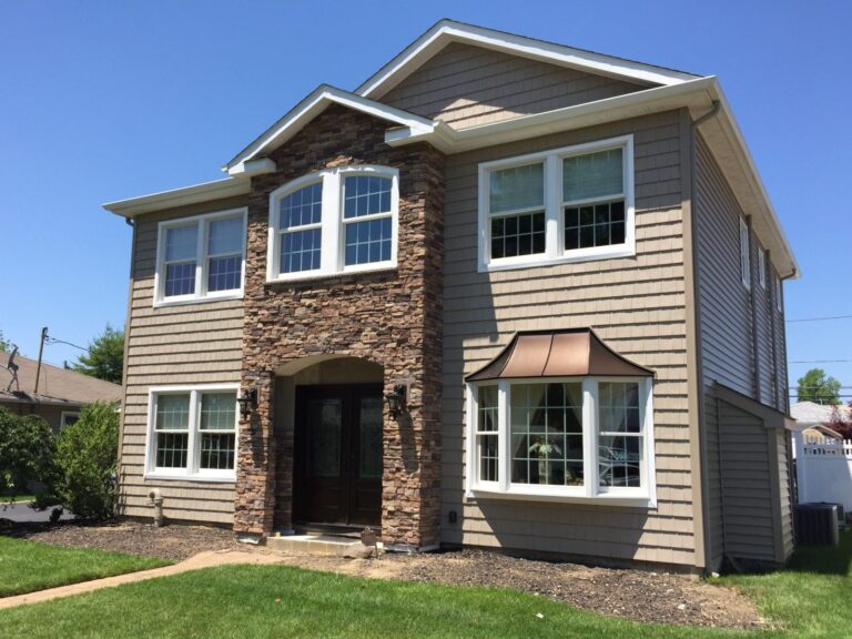 Two-story home with taupe siding and a stone veneer center section