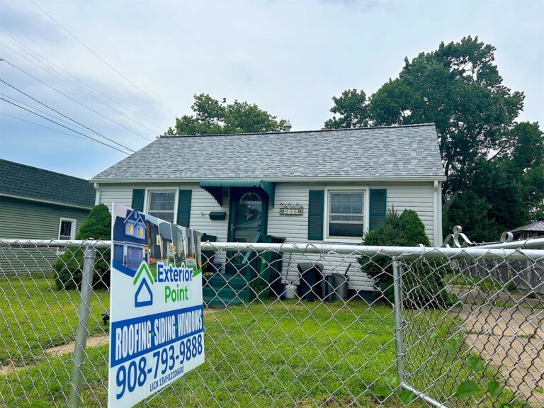 Cape Cod with a new gray shingle roof and Exterior Point yard sign in Keyport, NJ