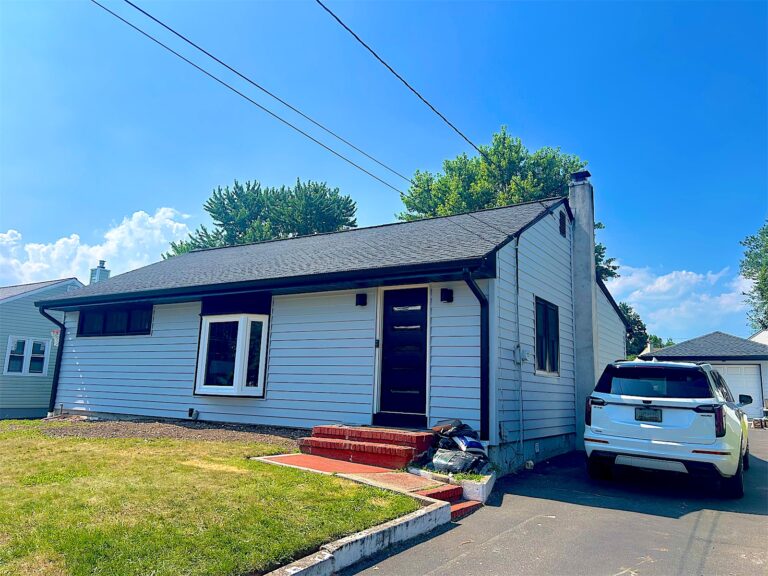 Ranch home with new light gray siding and black windows in Clark, NJ