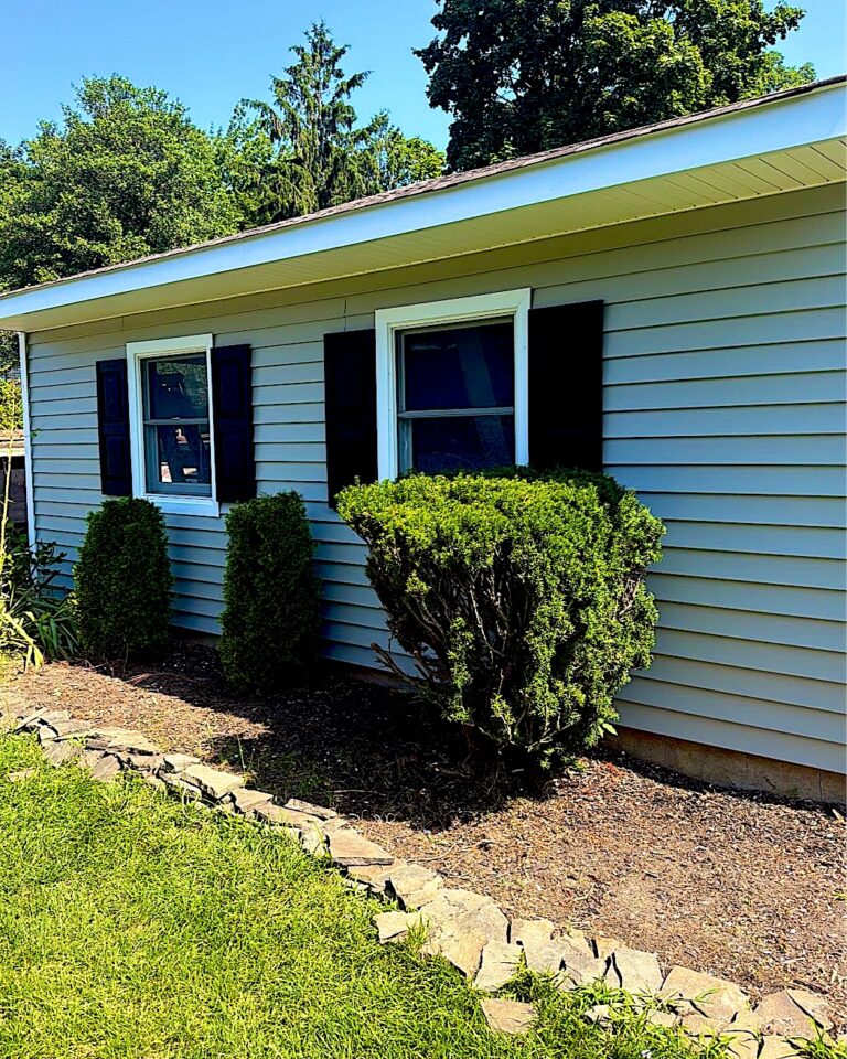 Ranch home with new light gray siding and black shutters in Neptune, NJ