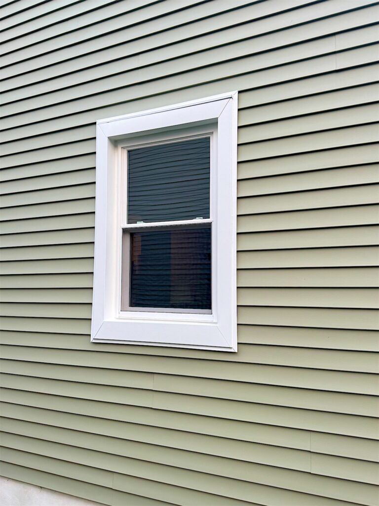 New white double-hung window on gray-green vinyl siding in Brick, NJ