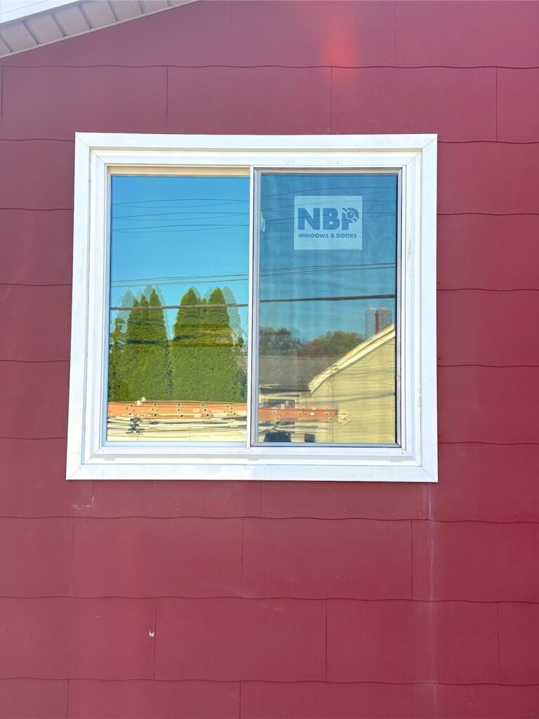 Newly installed white window in red siding in Keyport, NJ