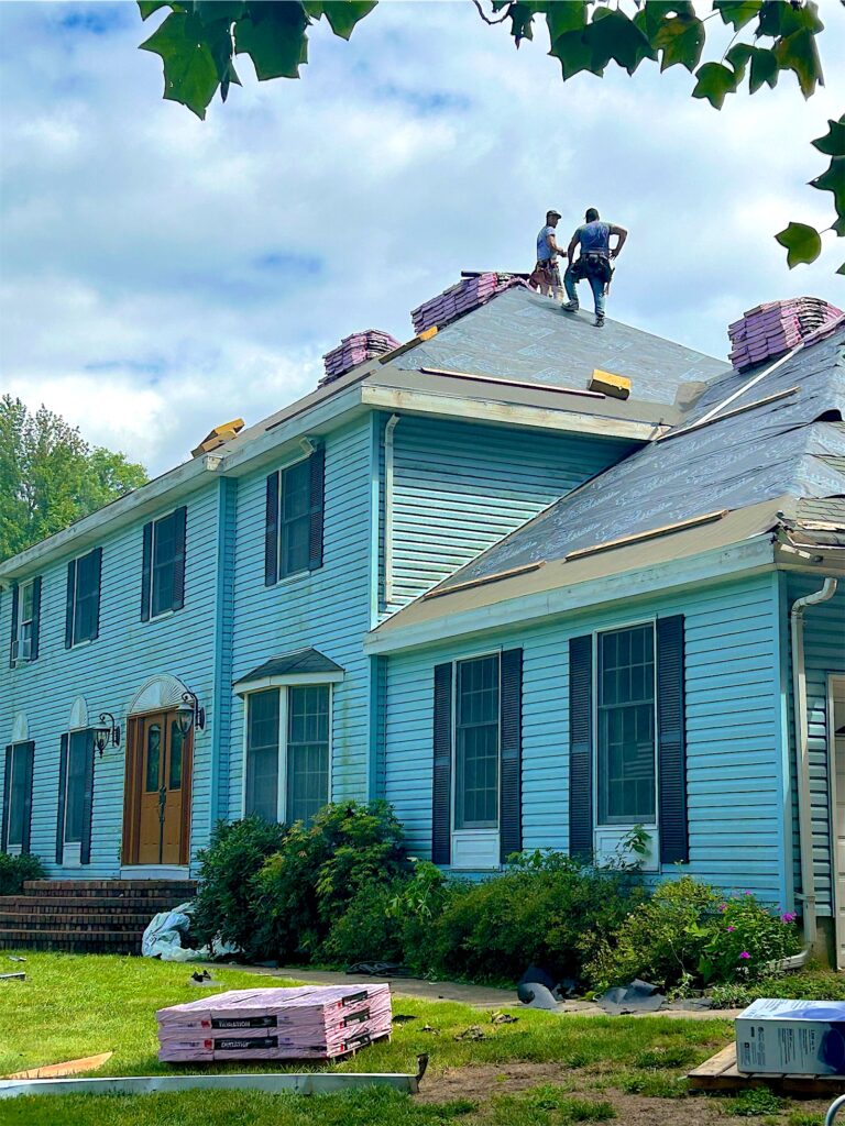 Exterior Point crew installing a new roof on a blue colonial in Lincroft, NJ